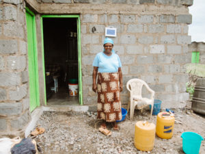 An African woman stands outside the door of abuilding